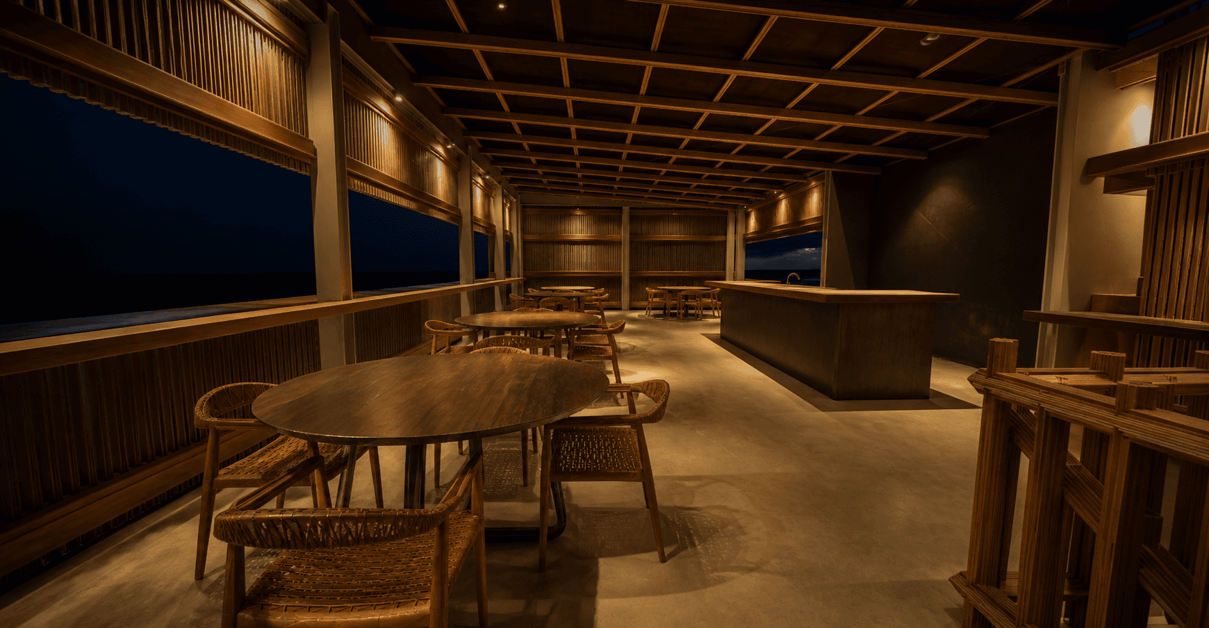 Salon et bar supérieur avec tables en bois éclairées par petits foyers
