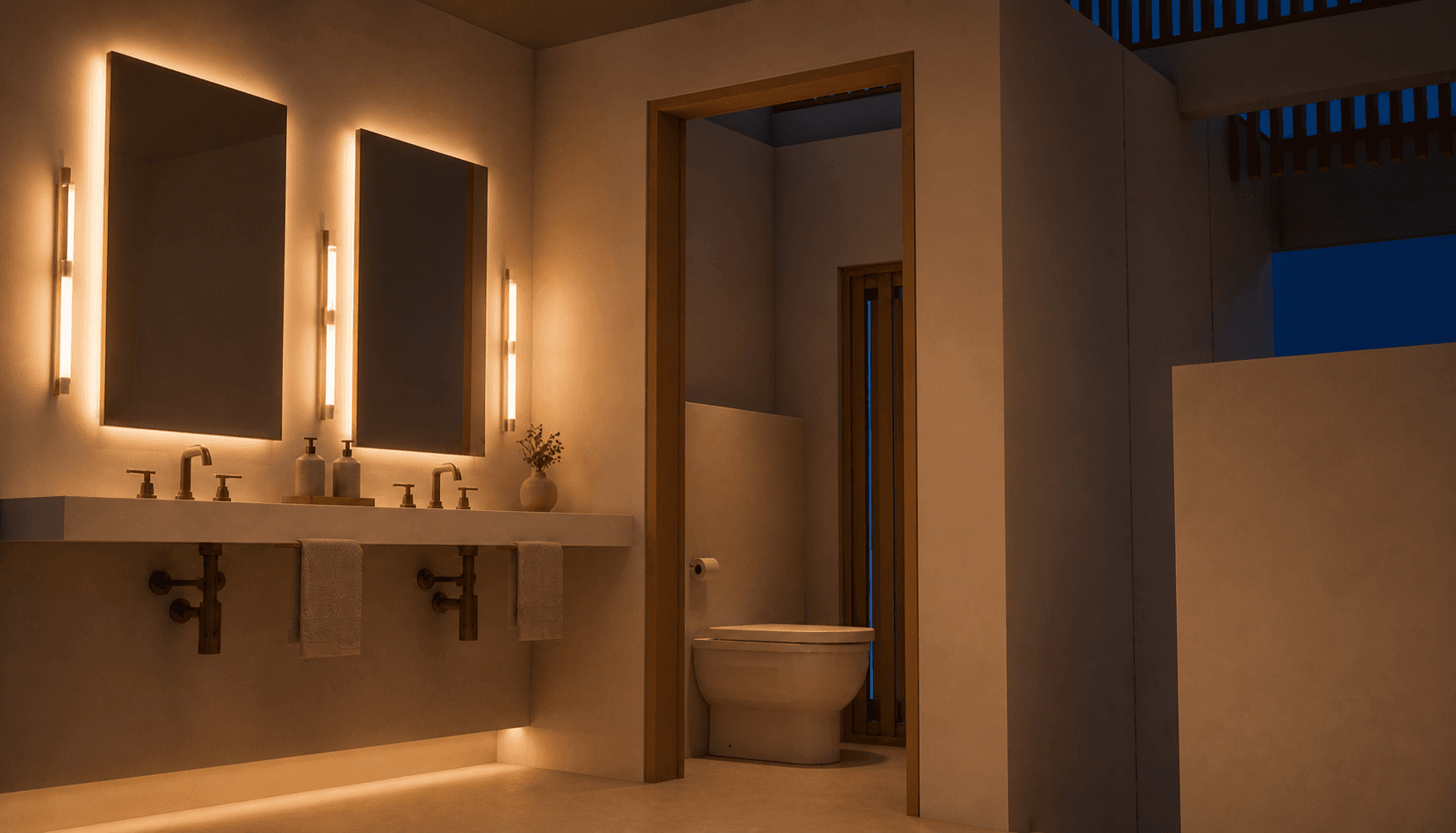 Salle d'eau parentale avec double vasque, miroirs lumineux et WC en retrait